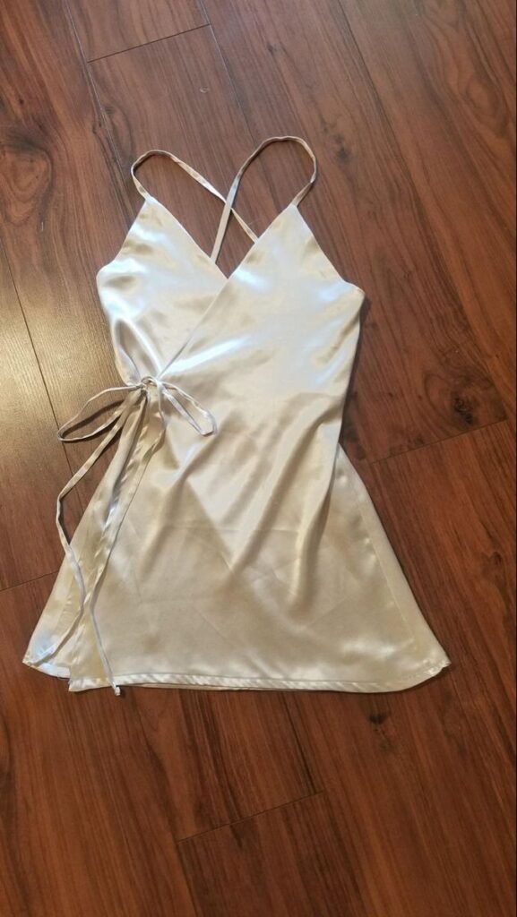 a champagne gold satin mini wrap slip dress with a V-neckline.